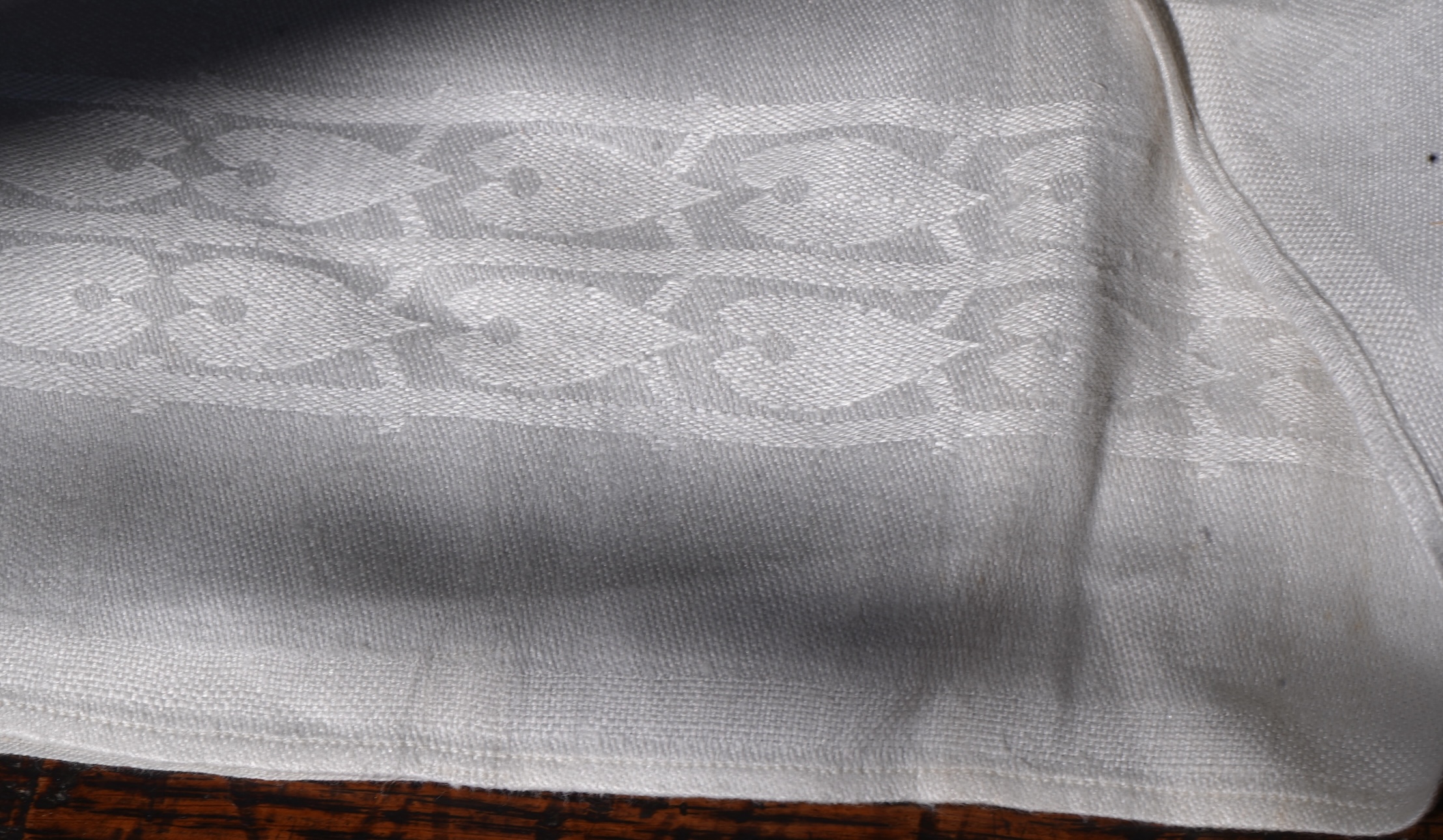 A set of four large Art Nouveau, unused white damask woven hand towels. The pattern having strong Archibald Knox and Walter Crane design elements; with trailing Honesty seeds and Tulip flower heads, these motifs much use